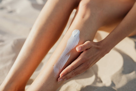 Woman putting lotion on her legs